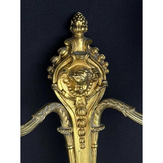 Elegant late-19th-century French Louis XVI-style gilt bronze wall sconce featuring finely cast neoclassical ornamentation....