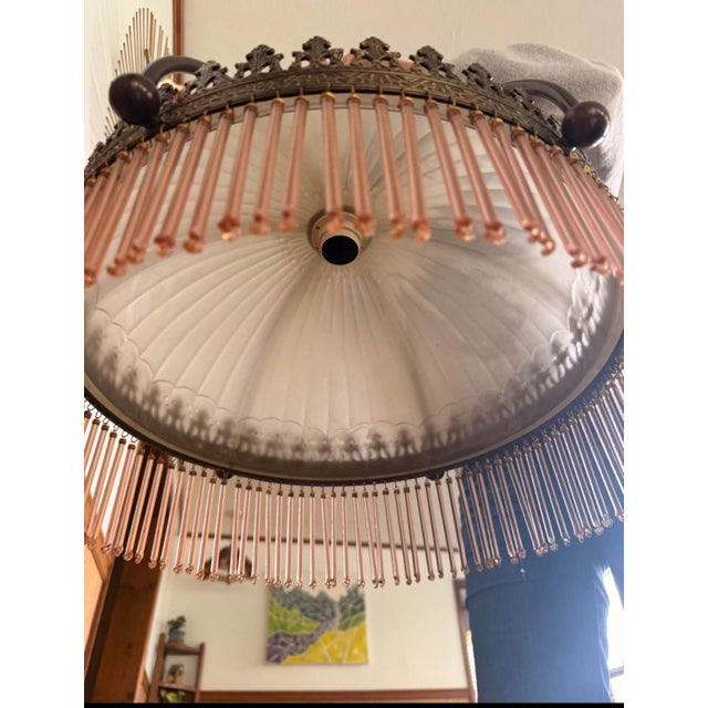 Incredibly intricate 1920s/30s era chandelier. Features a frosted glass dome held in place by sculpted brass arms and...