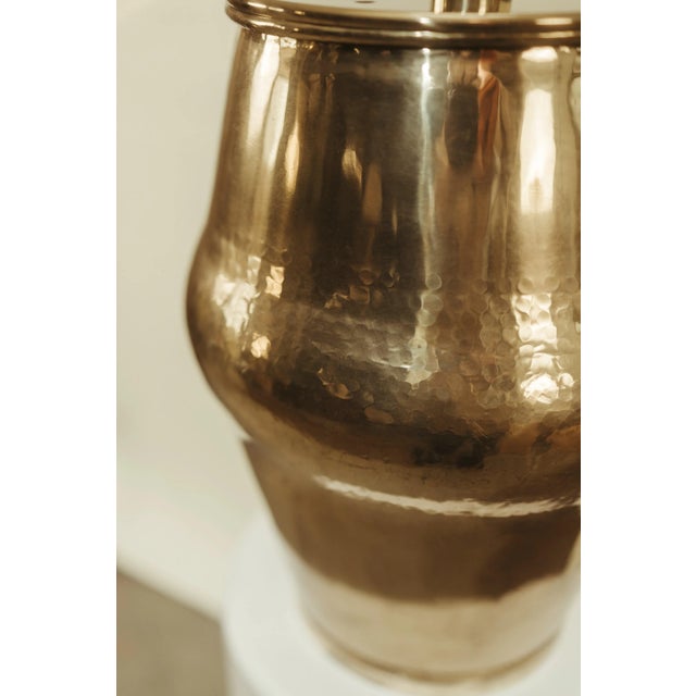 A timeless vintage hammered brass table lamp with a soft pleated linen shade. The handcrafted brass base features gentle...