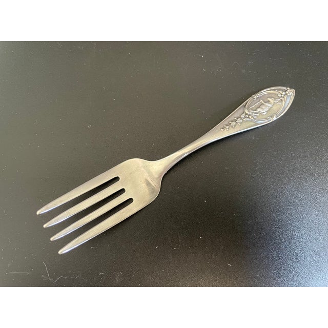 A lovely antique baby fork in the WED24 pattern by Weidlich Sterling Spoon Co., featuring a pointed handle accented with a...