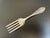 A lovely antique baby fork in the WED24 pattern by Weidlich Sterling Spoon Co., featuring a pointed handle accented with a...