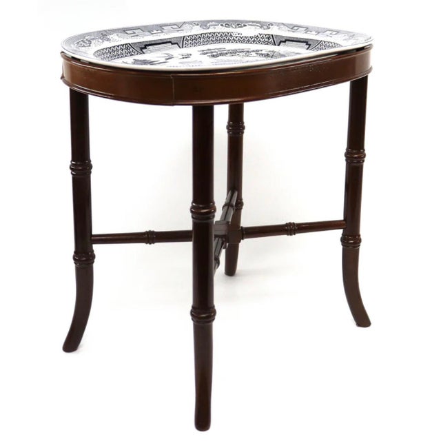 A vintage Chinoiserie style tray top table. This removable, oval top table with willow ceramic platter sits in a mahogany...