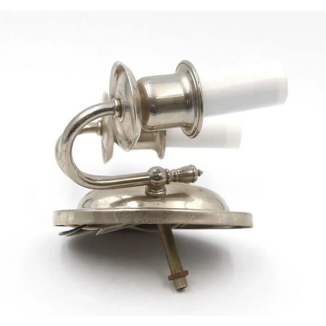 Traditional silvered brass two arm wall sconce with an oval back plate. This is wired and ready to ship. The manufacturer...