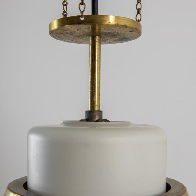 Art Deco glamor meets Industrial simplicity in this vintage brass pendant lamp. Made in Czechia in the 1970s, the wide,...