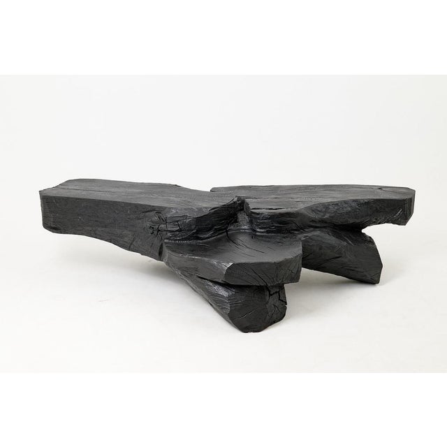Carved from solid hardwood, this coffee table reads more like a landscape than a piece of furniture. The surfaces spread...