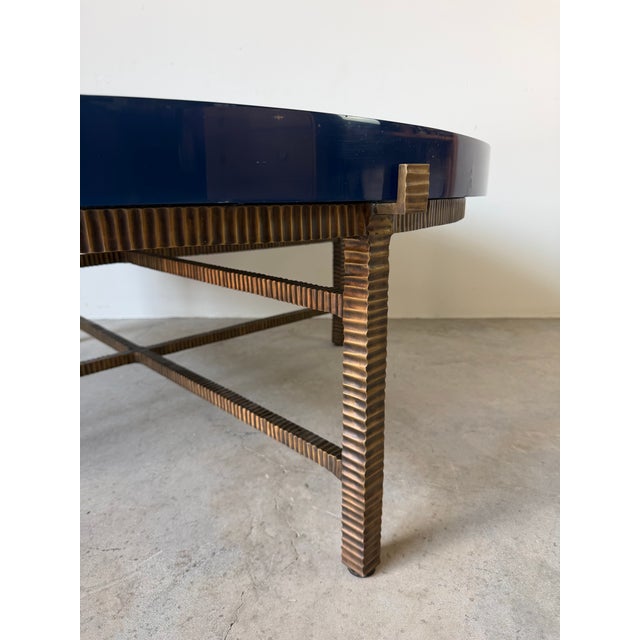 Striking modern coffee table by Donghia featuring a sculptural ribbed bronze base paired with a substantial round blue...