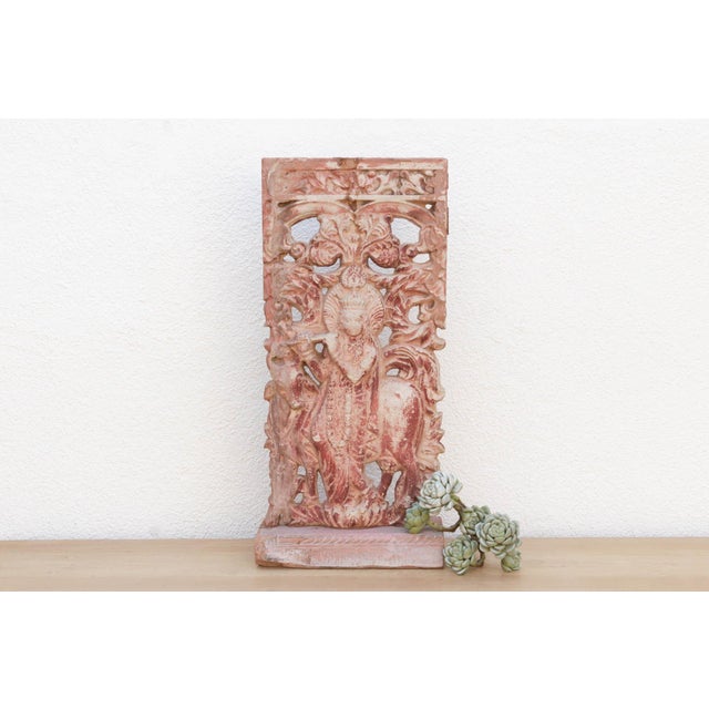 This vintage cast stone panel depicts the divine Krishna in a serene, leafy landscape, enchanting listeners with his flute...