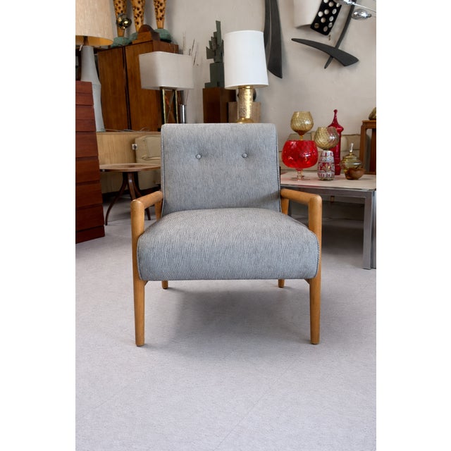 Lounge chair features open-arm frames of maple which support seats in a textured gray printed fabric. Flaw found in seat...