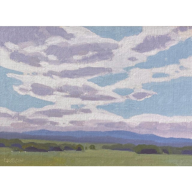 This oil painting captures a serene landscape under expansive blue skies, with soft, billowing clouds that evoke a sense...