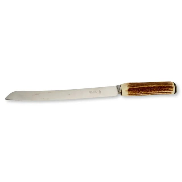 An authentic midcentury English bread knife featuring a naturally shed stag-horn handle and stainless-steel blade with the...