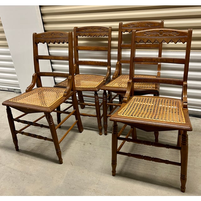 Popular turn of the century Eastlake style. Set of four dining chairs with original cane seats. Carved chair back and...