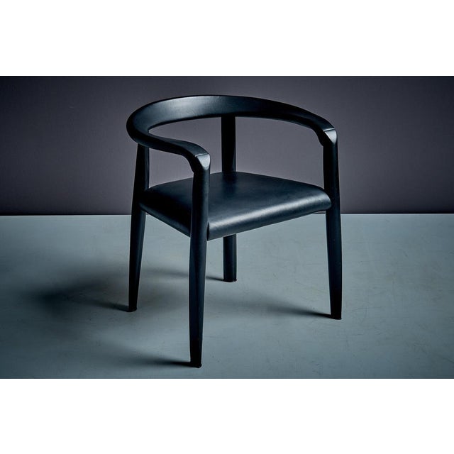 This set of six chairs, is the version with black leather upholstery to the seat and armrests, paired with frames in...