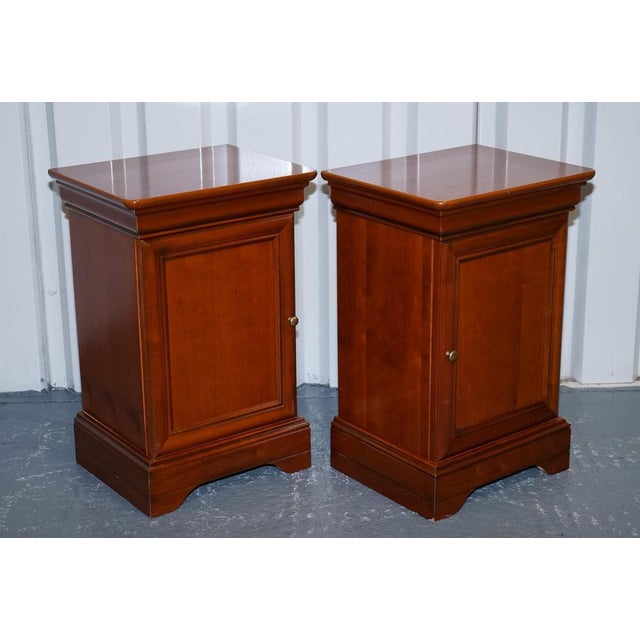 This elegant vintage pair of bedside tables is crafted in warm-toned cherry wood and inspired by classic French design....