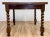 Antique square wood refectory table featuring rich grain and classic barley twist legs. Measures 59.5"L with leaves...