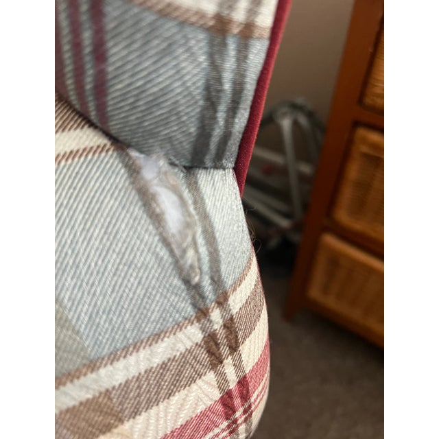This is a cozy plaid armchair and matching ottoman featuring rolled arms and a rounded backrest, ideal for tradional or...