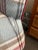 This is a cozy plaid armchair and matching ottoman featuring rolled arms and a rounded backrest, ideal for tradional or...
