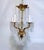 This ornate brass chandelier features a classic five arm candle‑style chandelier arranged around a sculpted central...