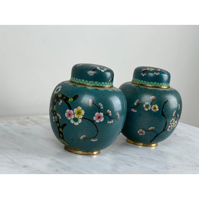 This lovely pair of vintage Chinese cloisonné ginger jars features a deep teal ground decorated with delicate flowering...