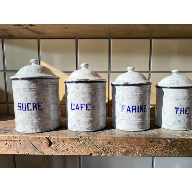 Charming complete and graduated set of six enameled tin kitchen tins, decorated with a blue marbled pattern on a white...
