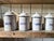 Charming complete and graduated set of six enameled tin kitchen tins, decorated with a blue marbled pattern on a white...