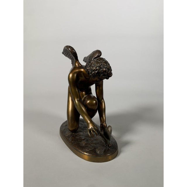 Patinated bronze sculpture by Antoine Chaudet (1763-1810), depicting Cupid playing with a butterfly. Bronze with a golden-...