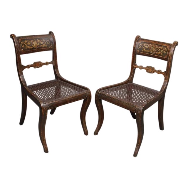 Each with crestrail painted with eagles over a caned seat, raised on saber legs.