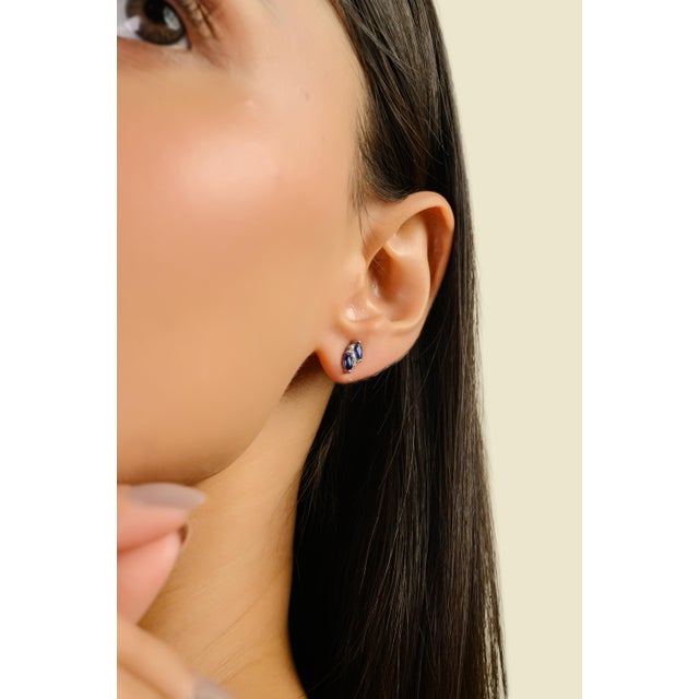 These elegant stud earrings showcase 4 marquise-cut natural blue sapphires totaling 0.63 carats, each measuring...