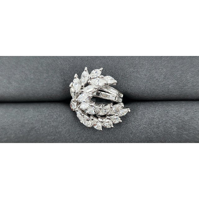 This gorgeous platinum ring weighs approximately 5.50 ct. The ring features marquis, rounds, and baguettes boasting F/G in...