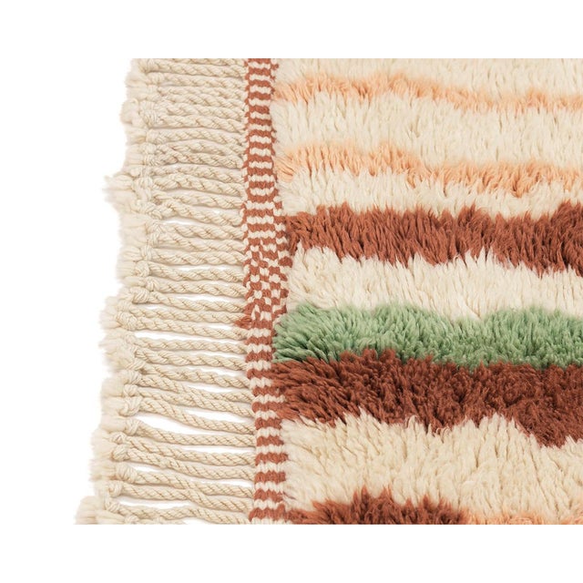 Rain-like streaks of color, cascading down an ivory field. This hand-knotted wool rug builds its composition from...