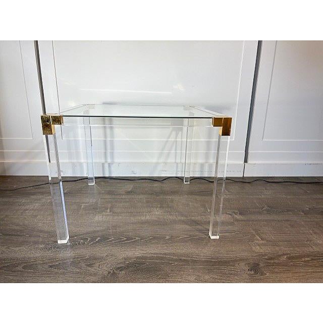 Chic, vintage, mid-century modern side table made of acrylic frame with brass corners and an inlaid glass top made in the...