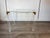 Chic, vintage, mid-century modern side table made of acrylic frame with brass corners and an inlaid glass top made in the...