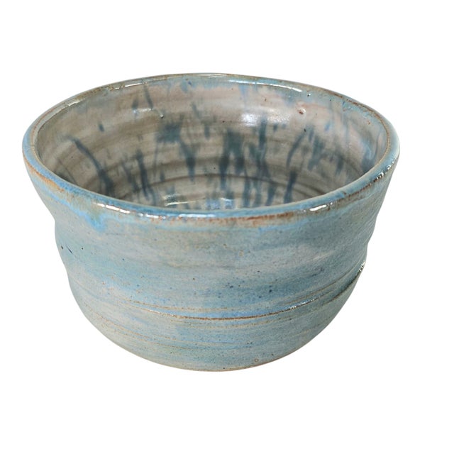 This vintage studio art pottery bowl is wheel-thrown in terra cotta and finished with a fluid baby-blue drip glaze that...