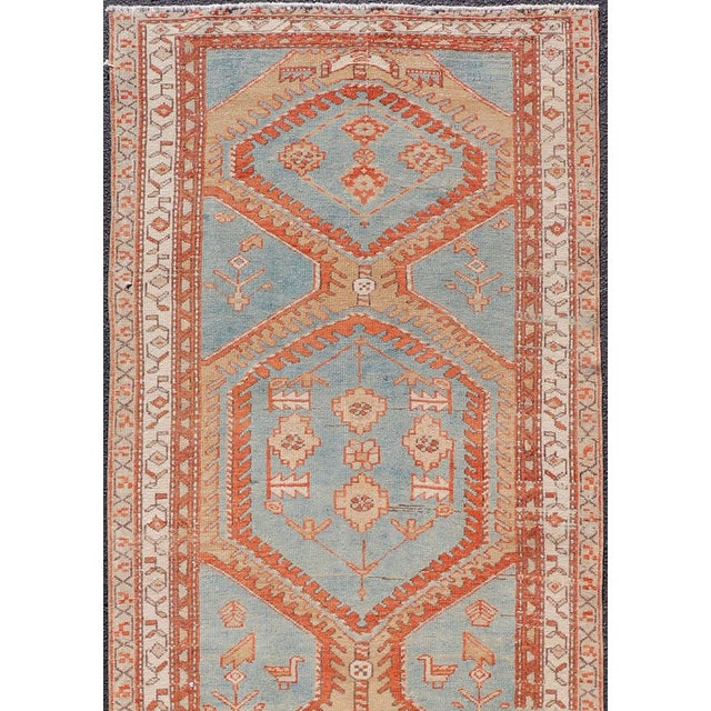 This antique Persian Karajeh runner features a tribal sub-geometric triple medallion design rendered in multicolor, set...