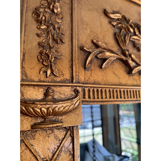 French Louis XVI style giltwood trumeau mirror features an ornate upper cartouche with a ribbon and tassel motif.