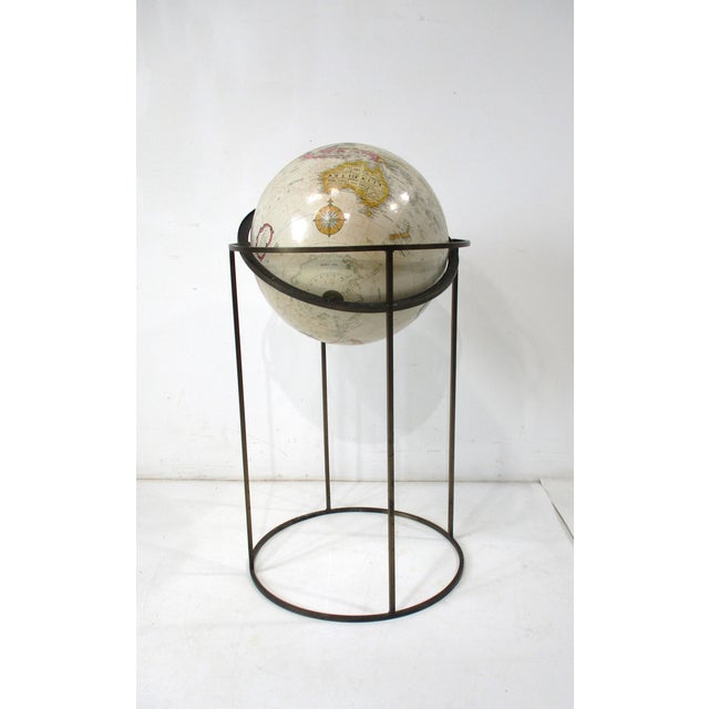 A Mid Century globe on a square tube patina brass stand with the globe mounted on the axis having celestial horizon...