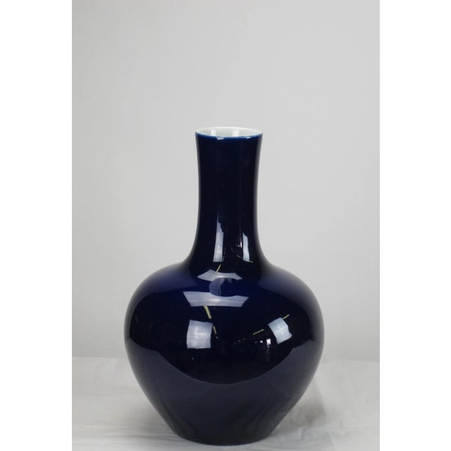This vase with glossy dark blue finish has long straight neck and smooth rounded base. Each one is hand made by an artisan...
