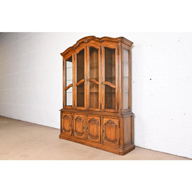 A beautiful French Provincial Louis XV style lighted breakfront bookcase or dining cabinet By Drexel Heritage USA, 1970s...