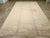 An antique Turkish Oushak oversize carpet. A round light brown medallion is freely placed on a beige ground in this...