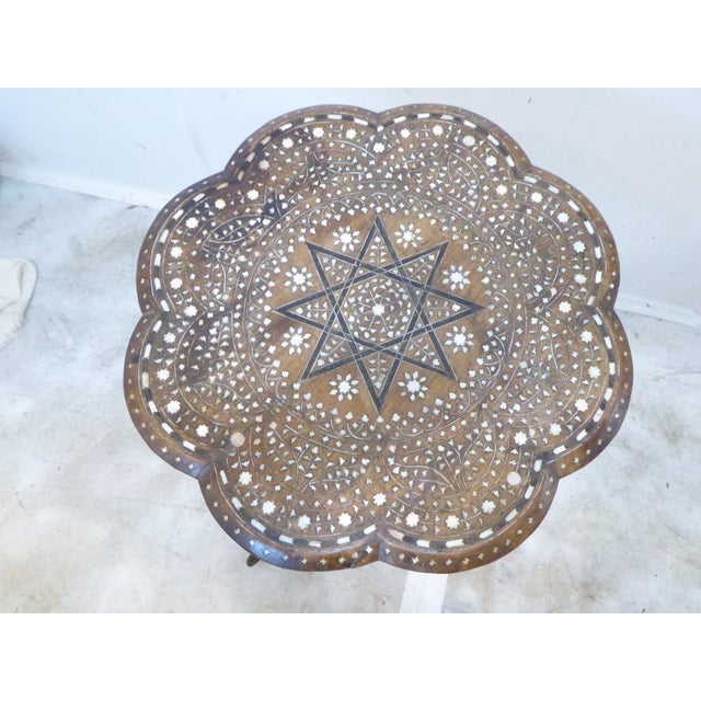 This Anglo-Indian inlaid wooden top is on an iron tripod base.