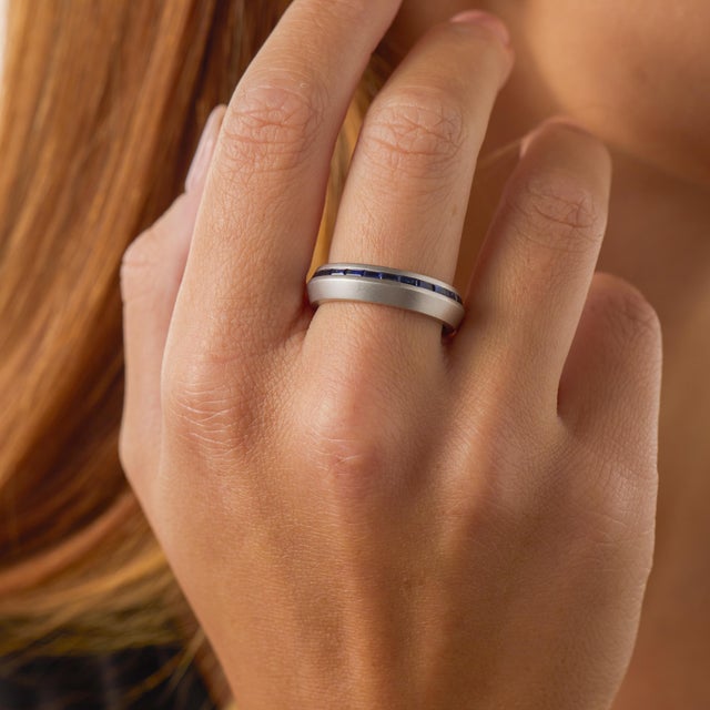This contemporary eternity band by Lugano showcases a continuous row of 27 baguette cut sapphires totaling approximately...
