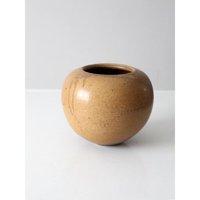 A signed vintage handmade studio pottery vase featuring a beautifully rounded form and organic modern presence. The warm...