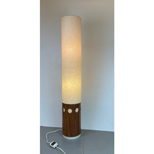 Tall and warm Mid-Century floor lamp in two parts. A teak cylindrical base supports a beautiful lampshade in textured...