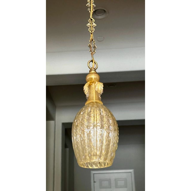 Smaller scale single 1950's Murano Italian hand blown ribbed glass hanging ceiling pendant light. Has gold inclusions and...