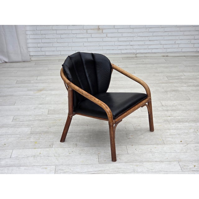 1970s, Danish armchair. Original brown rattan, black artificial leather. Original good condition: no smells, no stains and...