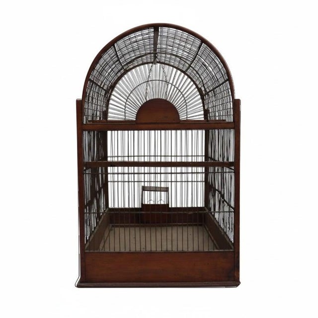 This antique English bird cage, dating from the 19th century, features a distinctive arched wire top set upon a sturdy...