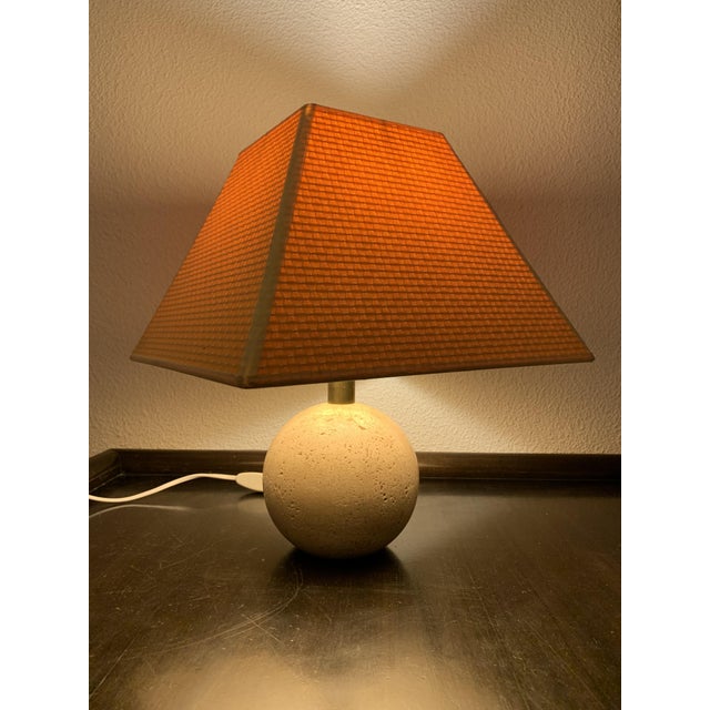 Very well preserved, delicate table lamp with a travertine base, brass neck and lamp shade by Pierre Frey from Paris....