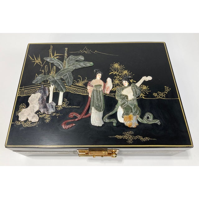 Large rectangular Asian style jewelry box with a decorative cut stone scene to top lid. Interior top lid is tufted blue...