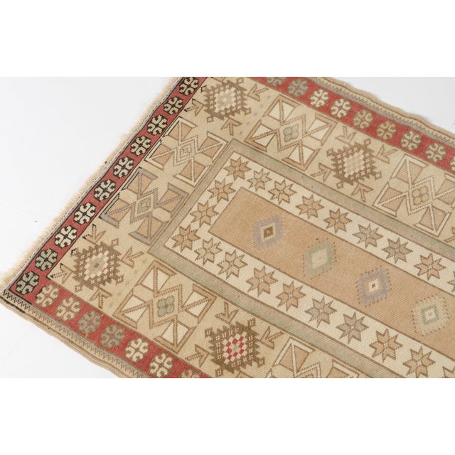 This is a vintage Turkish Oushak rug from the Mid 20th Century. The piece was hand-knotted.