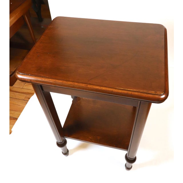 Traditional style end table made of dark stained wood and features a bottom shelf. Good condition with some scratches and...