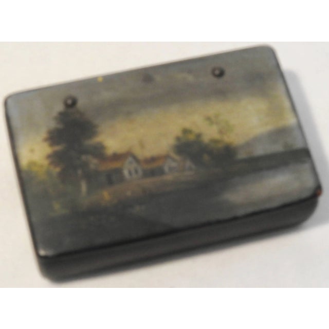 We are offering an antique black lacquer box from Russia with a hand painted landscape scene. It features a house along...